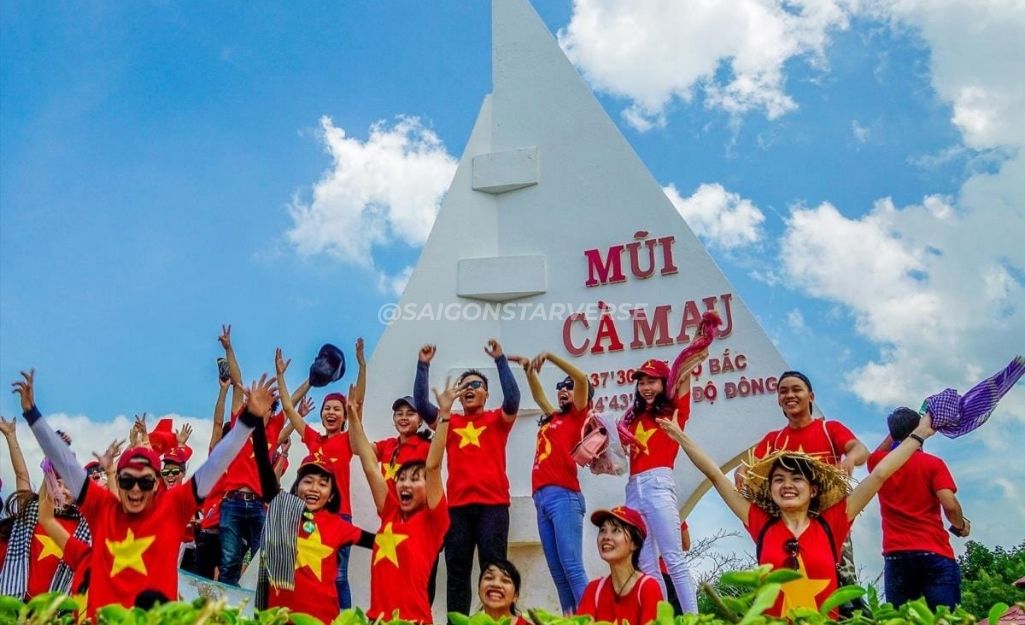 Tourists taking photos at the ship-shaped Cape Ca Mau monument