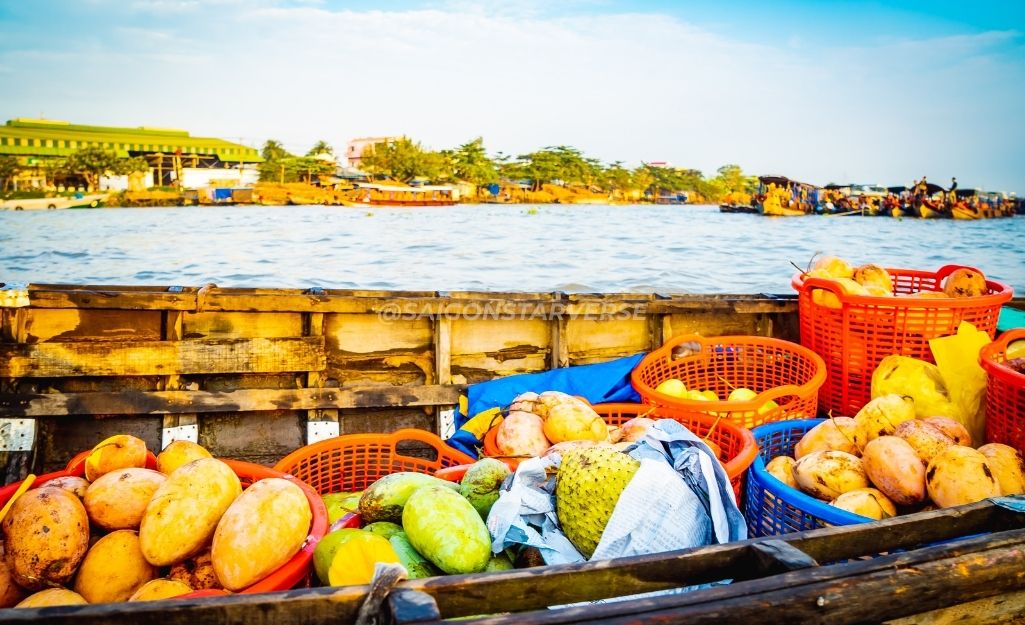Woman in conical hat selling fruits from her wooden boat