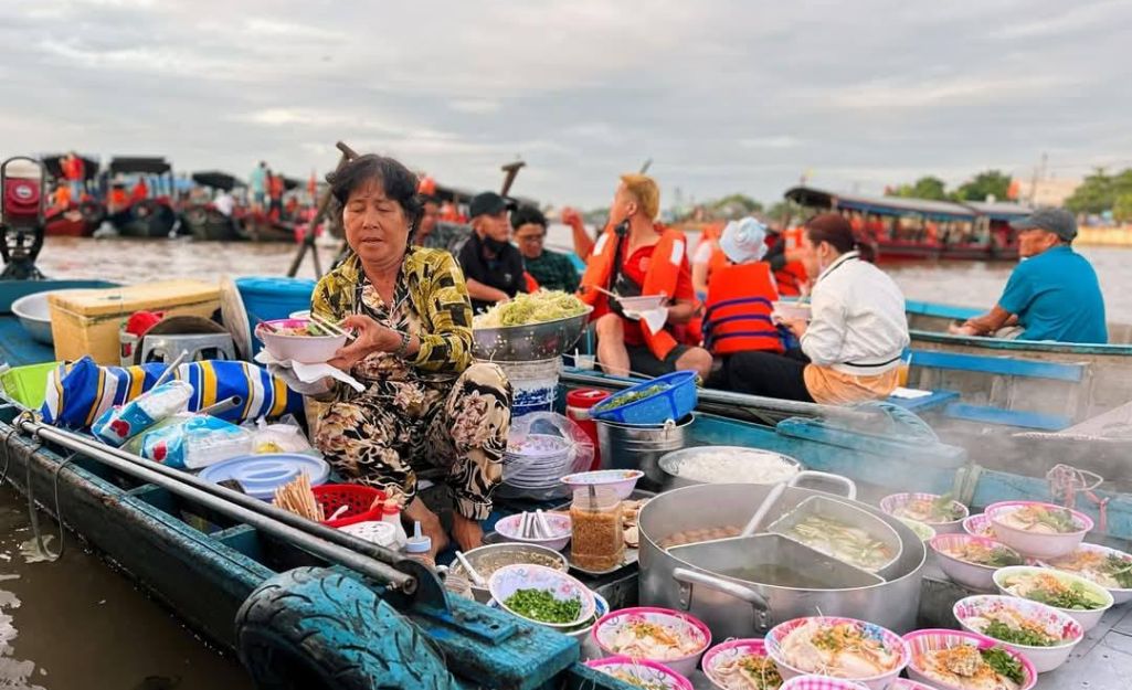 Tourist eating pho on a boat at Cai Rang Floating Market