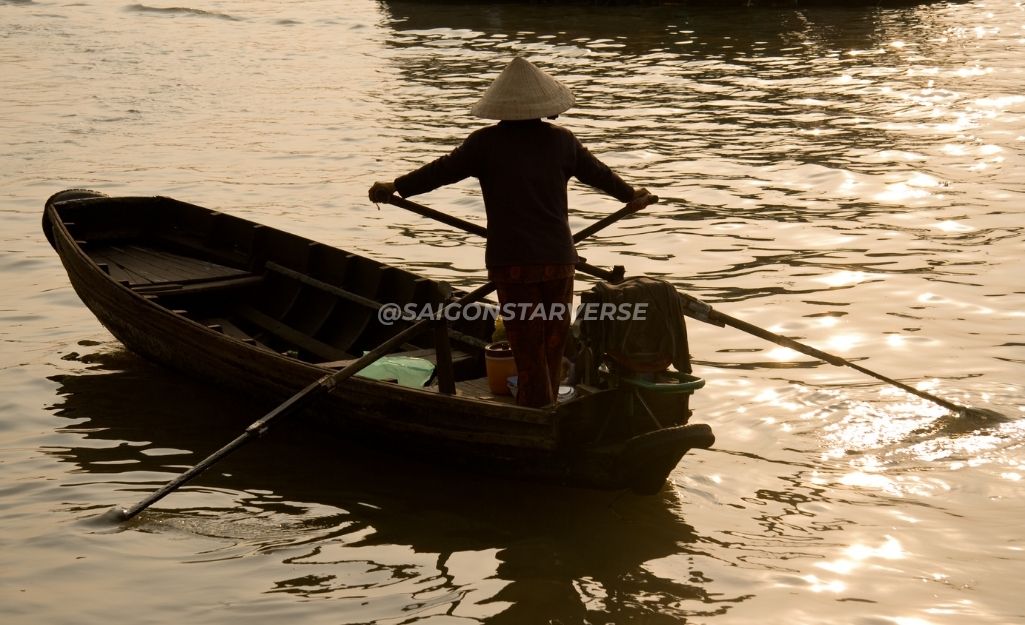 Người phụ nữ chèo xuồng đi lại mua bán trên sông ở Miền Tây